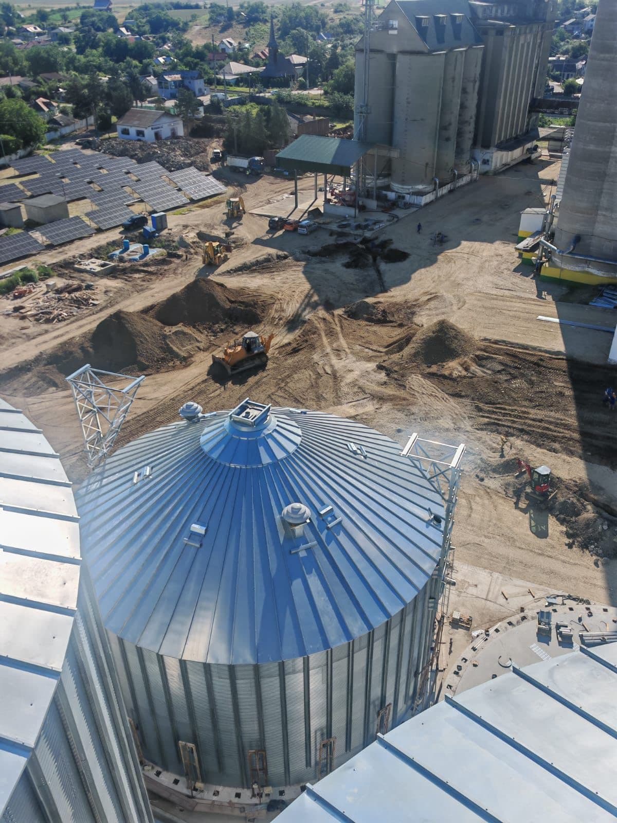 Grain silo complex with industrial conveyors at golden hour