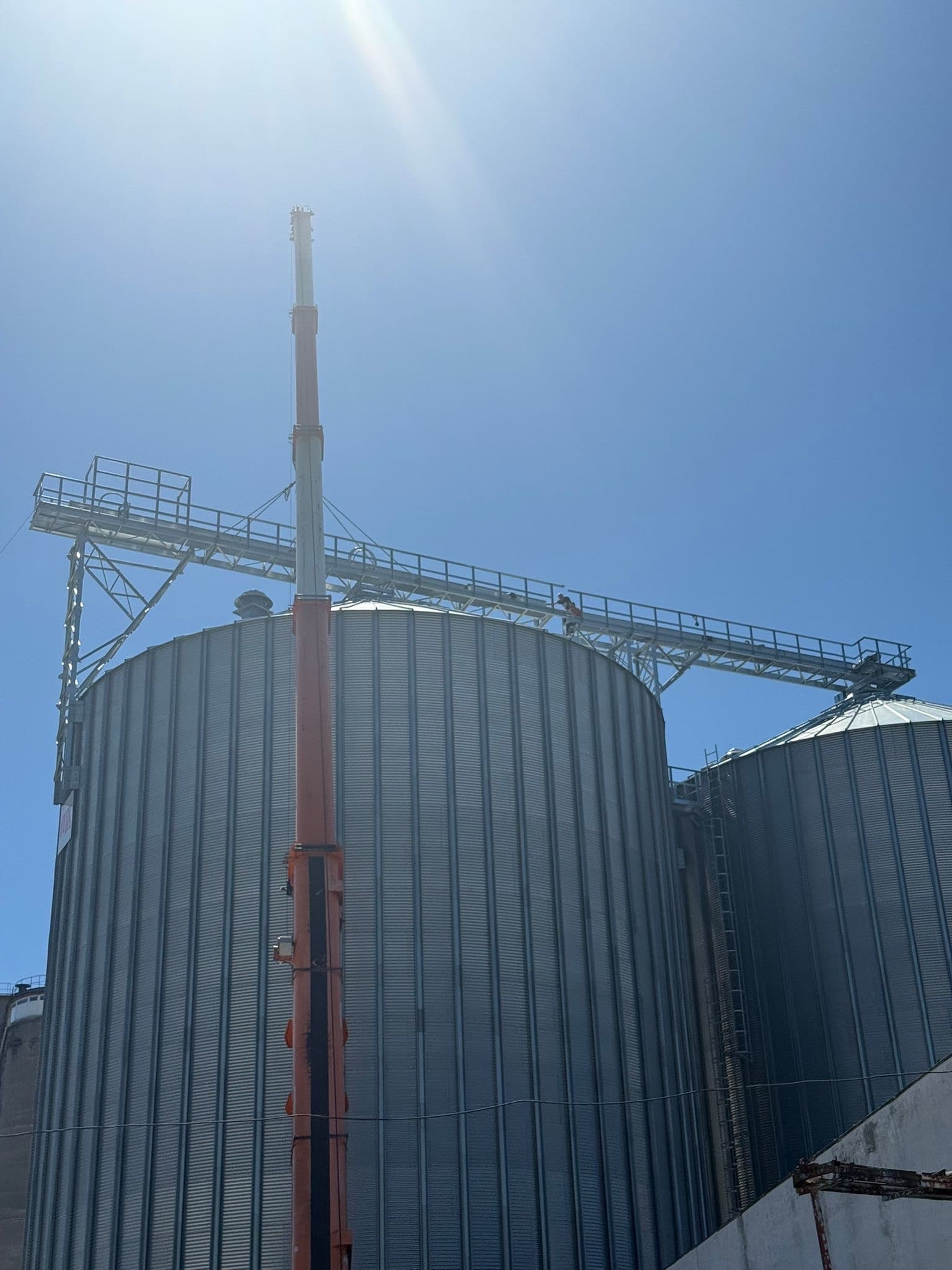 Grain silo complex with industrial conveyors at golden hour